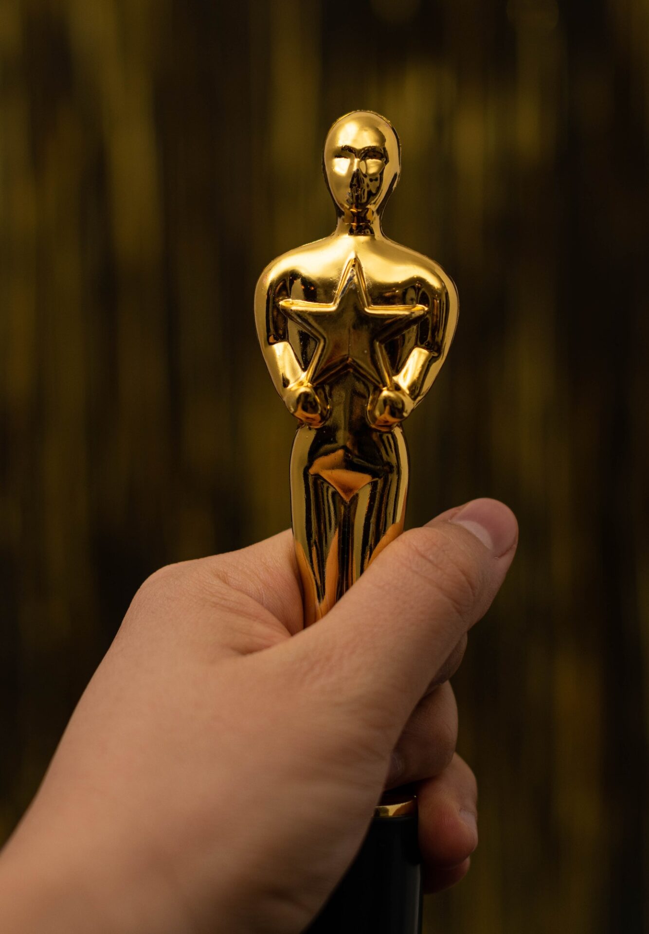 Woman hand holding a plastic Oscar award